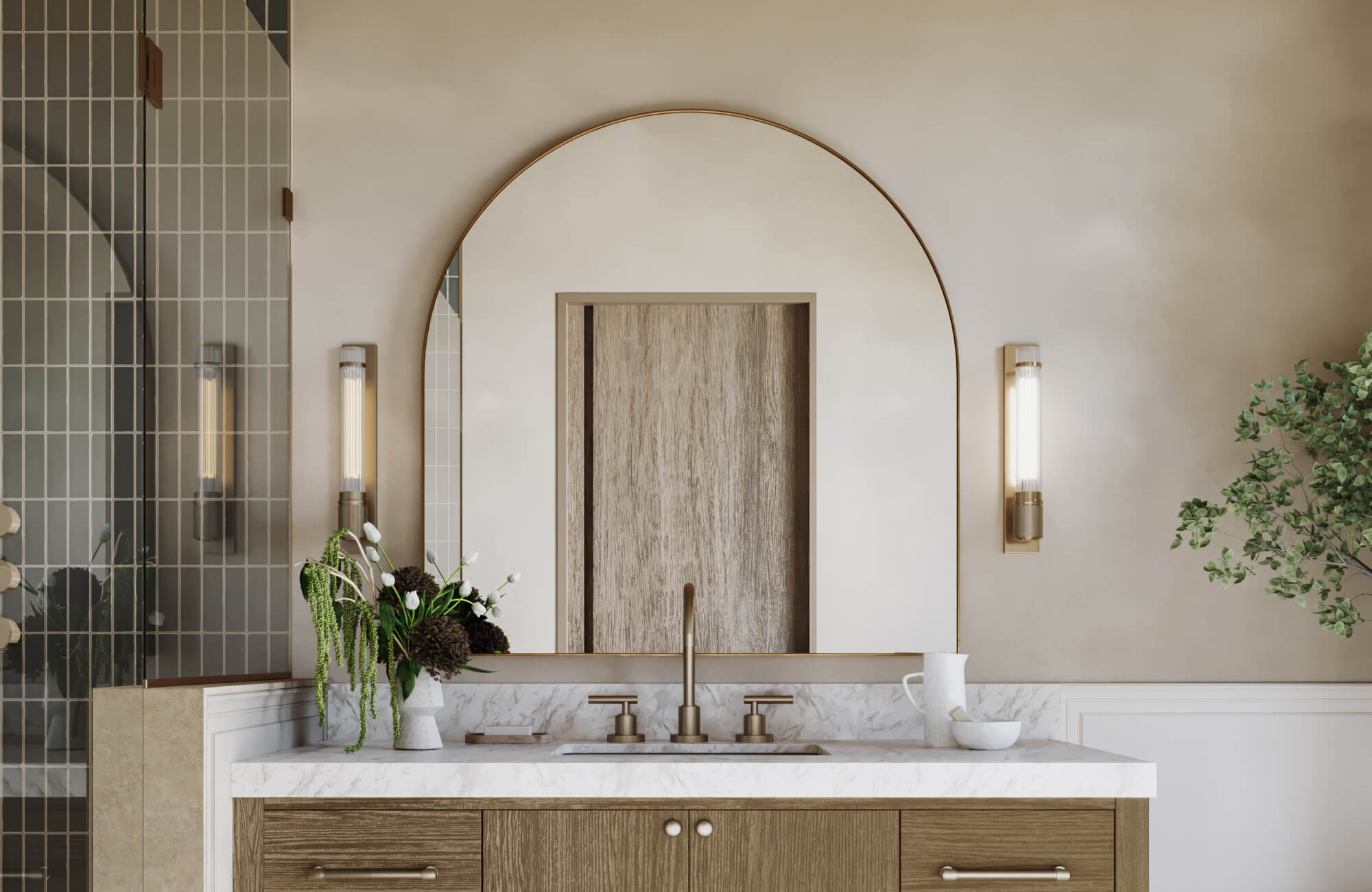 null Elegant bathroom with arched brass mirror, fluted glass sconces, marble countertop, and wood vanity accented by fresh florals.