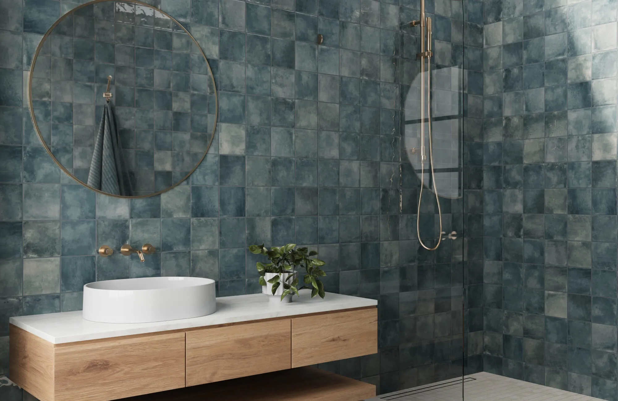 Modern bathroom with glossy blue square tiles, round mirror, floating wood vanity, and glass walk-in shower.