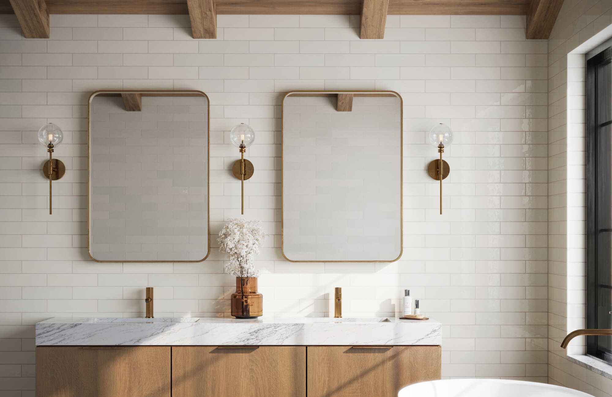 null Bright bathroom with glossy white subway tiles, wood vanity, marble countertop, and brass wall sconces.