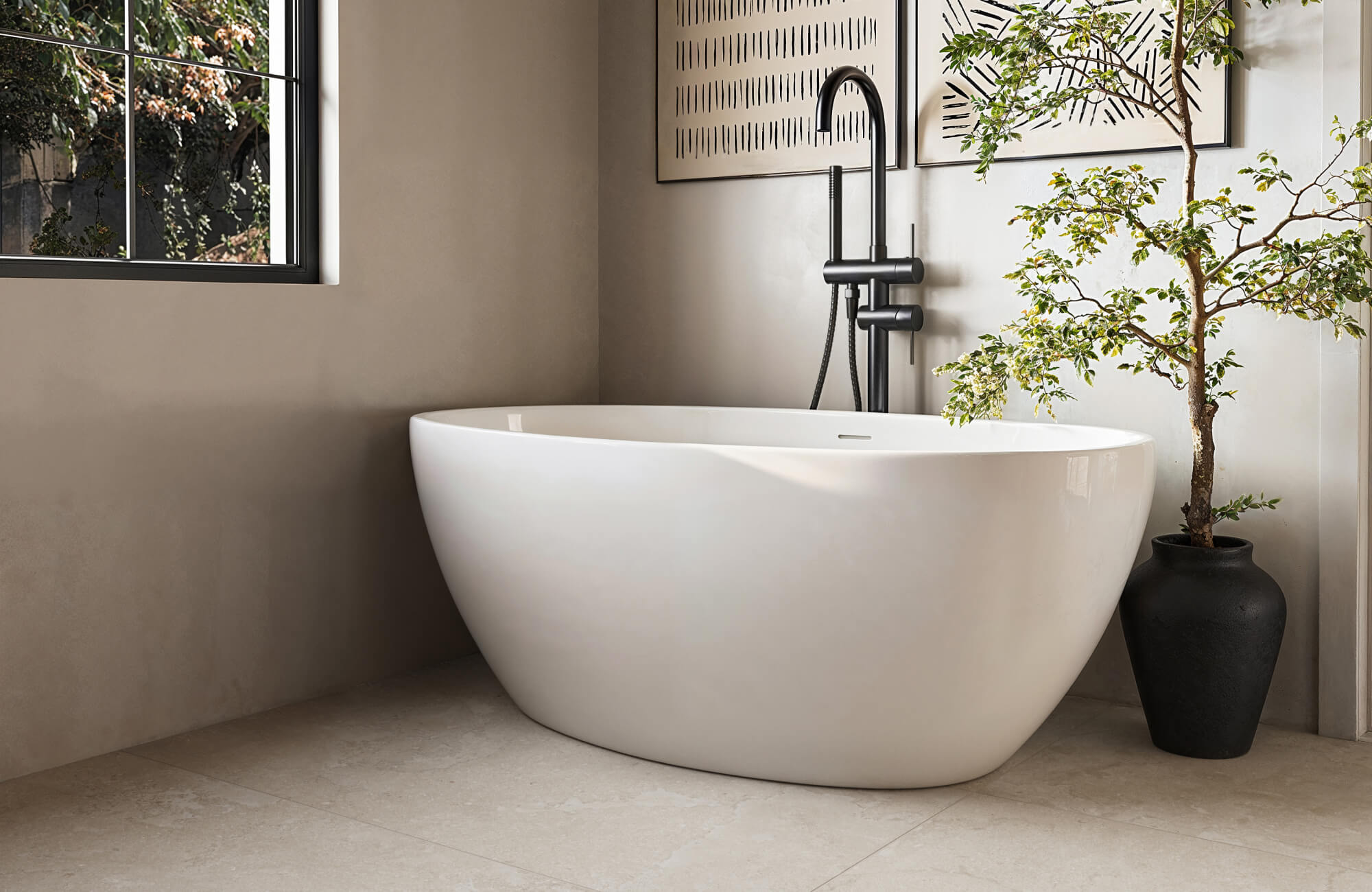 null Minimal bathroom with matte beige tiles, freestanding tub, black fixtures, and soft natural light.