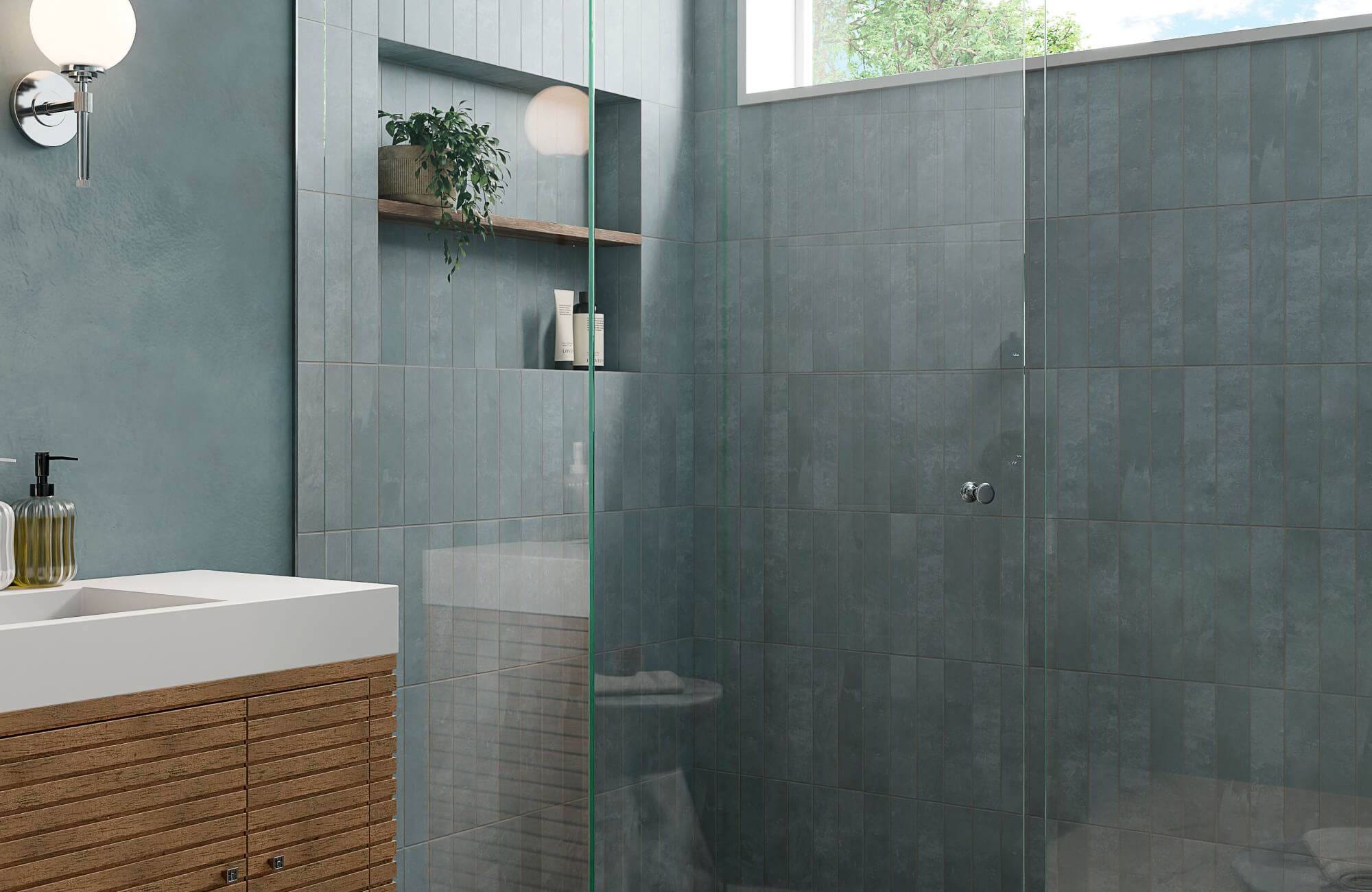 Matte blue bathroom tile with subtle texture, installed in a modern walk-in shower with glass enclosure and built-in niche shelving.