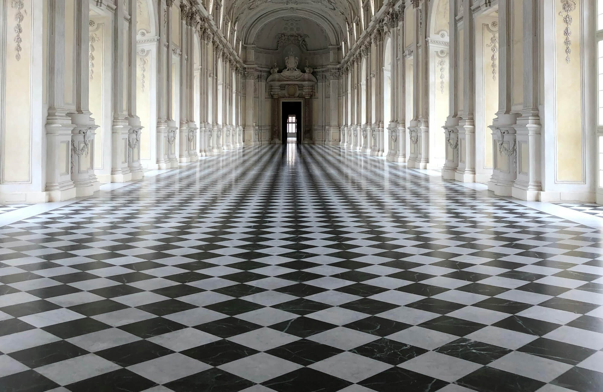 null Grand European hall with black and white checkerboard marble floor tiles, showcasing the historic architectural origins of checkered flooring.