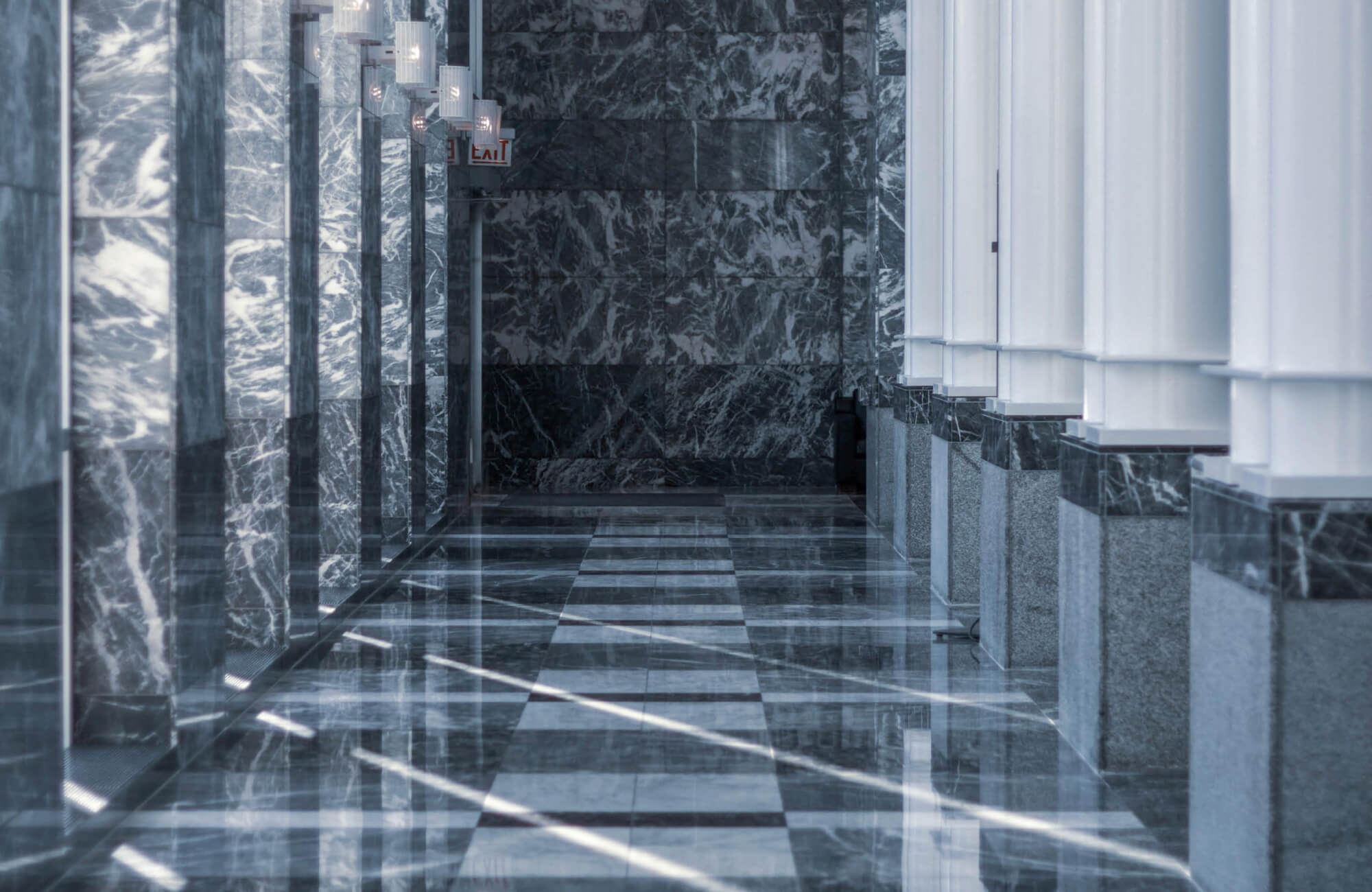Marble tiles in an outdoor setting with sunlight streaming across the glossy stone surface.