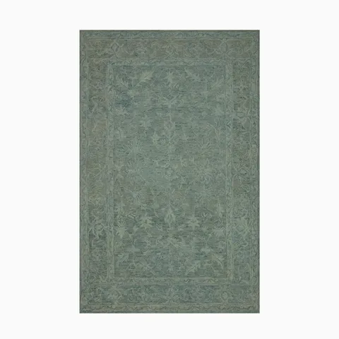 Hooked wool rug in deep forest green, featuring a tonal border design that adds texture and durability to transitional spaces.