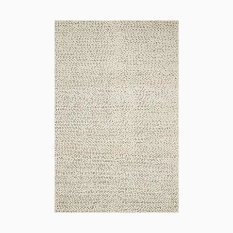 Made from a blend of wool and polyester, this handwoven rug has an off-white base with a plush looped texture, great for Scandinavian-style decor.