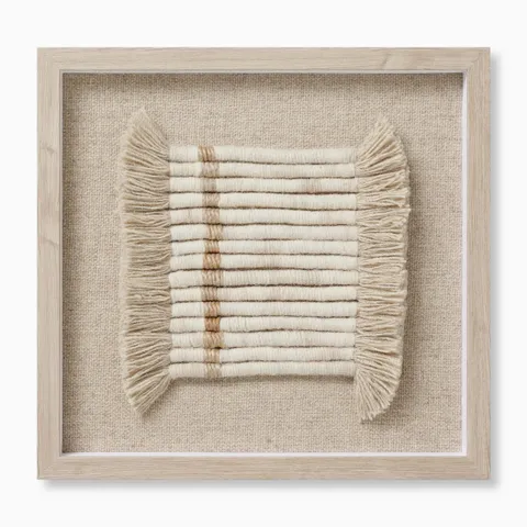 Textile wall art featuring tightly wound white wool yarn in clean linear rows, softened by cascading fringe and accented with warm beige and light brown tones.