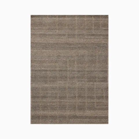 This 8'6" x 11'6" brown rug shows gentle shifts in tone and angular geometric lines, hand-loomed from an eco-friendly blend of wool, cotton, and polyester.