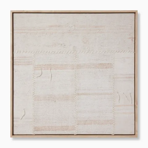 Framed textile artwork in soft neutral tones with visible stitched seams and subtle texture, evoking a handwoven, artisanal feel.