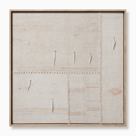 Square framed textile artwork with visible stitching, natural woven texture, and subtle hints of blush and rust on a neutral background.