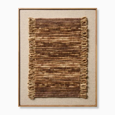 Framed textile wall art featuring a vertically oriented handwoven panel with layered brown and beige fibers, subtle fringe detailing, and a natural wood frame for a warm, organic, artisanal look.