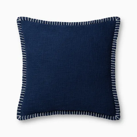 This dark blue pillow features a richly textured weave, white whipstitched flange edges, and an antique bronze zipper tucked behind a tailored flap, finished for breathable cotton comfort.