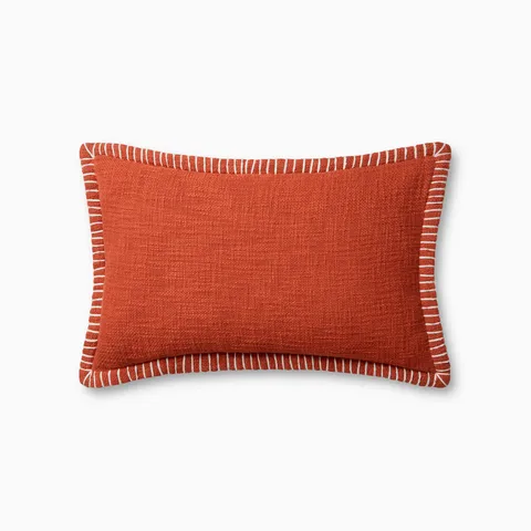 A rectangular orange pillow featuring a richly textured weave, white whipstitching at the flange edge, and an antique bronze zipper hidden behind a tailored flap, with a breathable cotton finish.