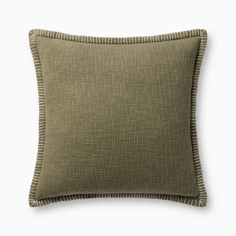 A soft olive green pillow with woven texture, white whipstitched flange edges, and an antique bronze zipper concealed by a tailored flap, finished with a light, breathable cotton feel.