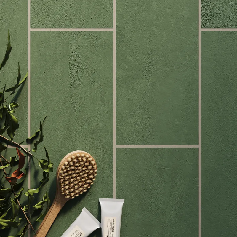 Dax Forest 6x24 matte porcelain tiles, featuring a deep green tone and textured surface, paired with natural bath essentials for a calming aesthetic.