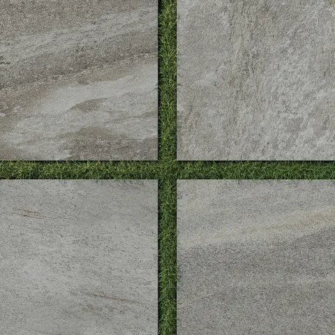 Carter Fossil 24x24 Matte Porcelain Pavers, 2cm thick, showcasing earthy grey tones with natural stone-like textures, complemented by green grass for outdoor elegance.