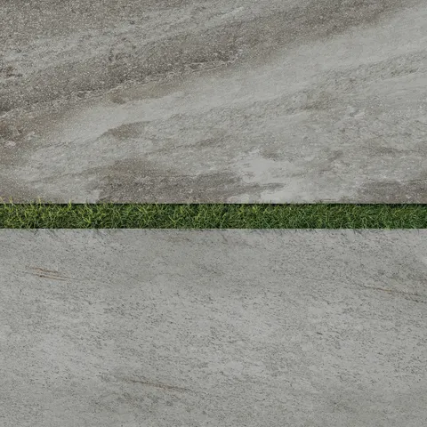 Close-up of Carter Fossil 24x48 Matte Porcelain Pavers, 2cm thick, showcasing a textured stone design with natural tones and lush grass accents.