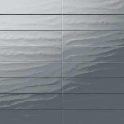 Palmer 6x24 glossy porcelain tile in blue-grey showcasing a rippled surface and reflective finish, ideal for modern bathroom walls.