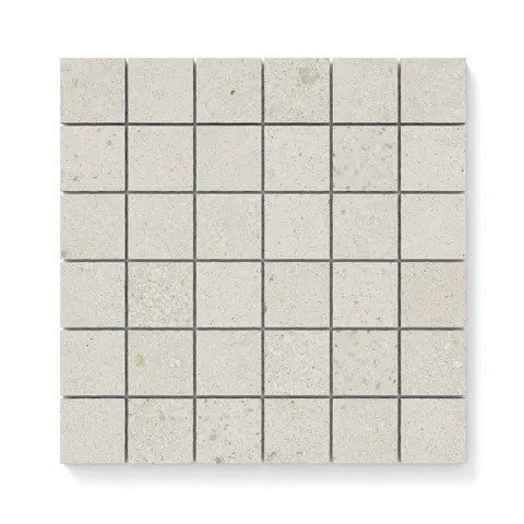 Close-up view of Sloane Pearl 2x2 matte tiles, highlighting their soft cream tone with delicate speckled details for a refined finish.