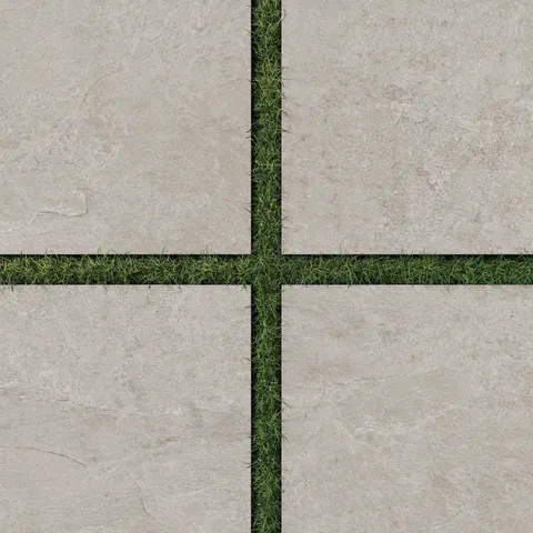 Dawson 24x24 Grip Porcelain 2cm Paver Tile in Dune, displayed with grass joints to highlight its warm, natural tone and textured surface.