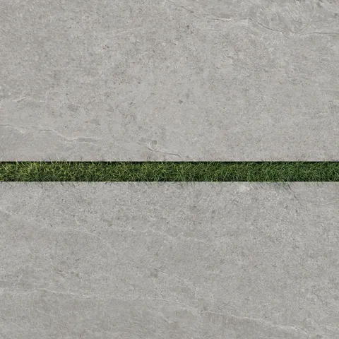 Dawson 24x48 Grip Porcelain 2cm Paver Tile in Ash, showcasing its light gray tone paired with a strip of vibrant green grass.