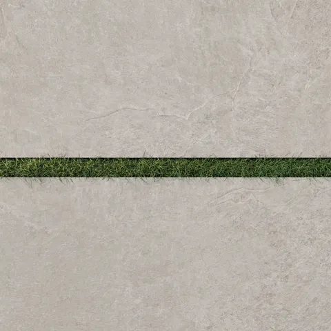 Dawson 24x48 Grip Porcelain 2cm Paver Tile in Dune, showcasing its warm beige tone bordered by a strip of green grass.
