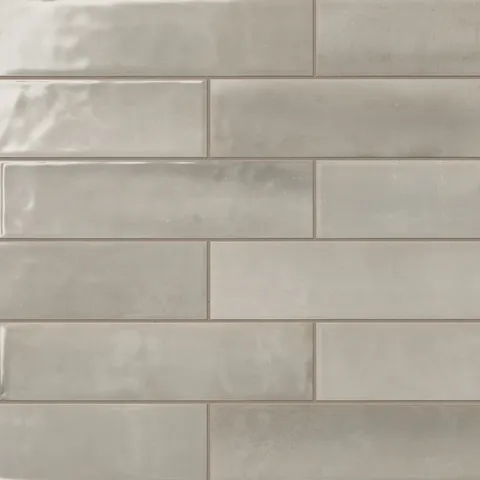 Taupe 4x16 subway tiles with a glossy finish and delicate natural patterns create an inviting, modern aesthetic that radiates warmth and charm.