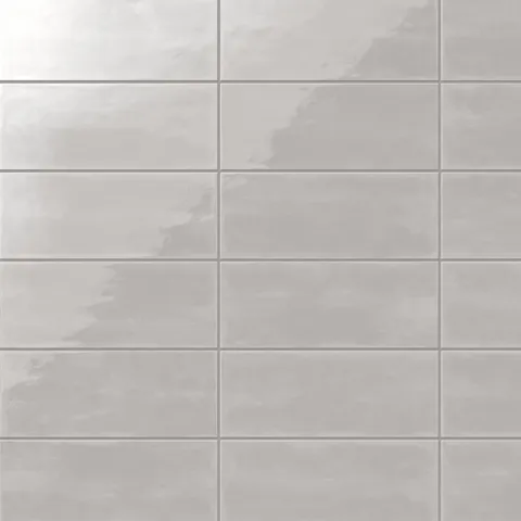 Glossy 4x10-inch ceramic subway tiles in a light gray hue, arranged in a clean and uniform grid pattern
