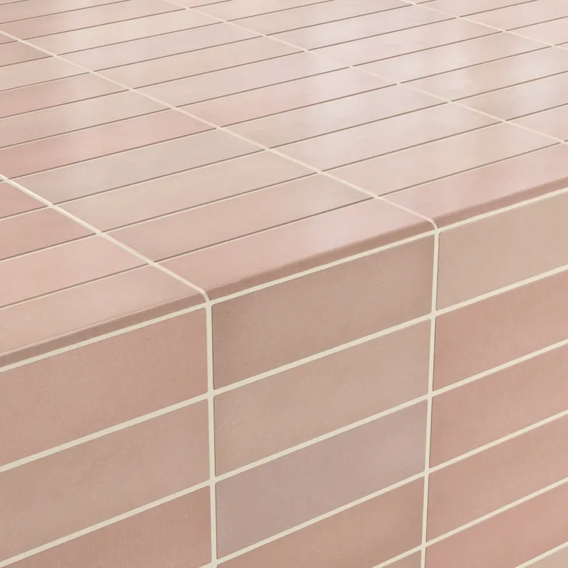 Pink-toned matte tiles arranged in a seamless grid, showcasing elegant 2.5x8 bullnose edges