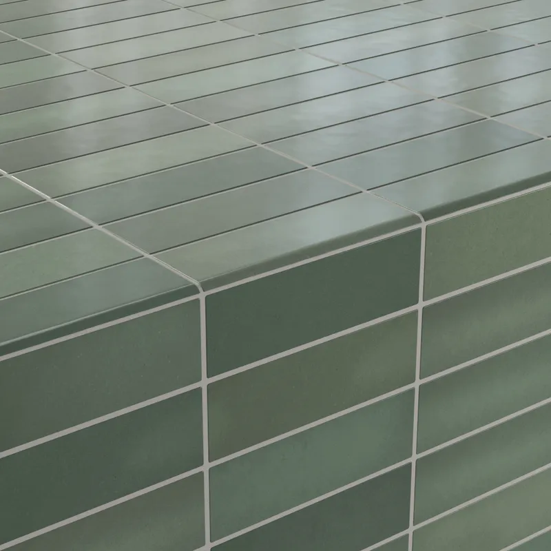 Close-up of corner detailing with deep green matte bullnose tiles, creating seamless and polished edges