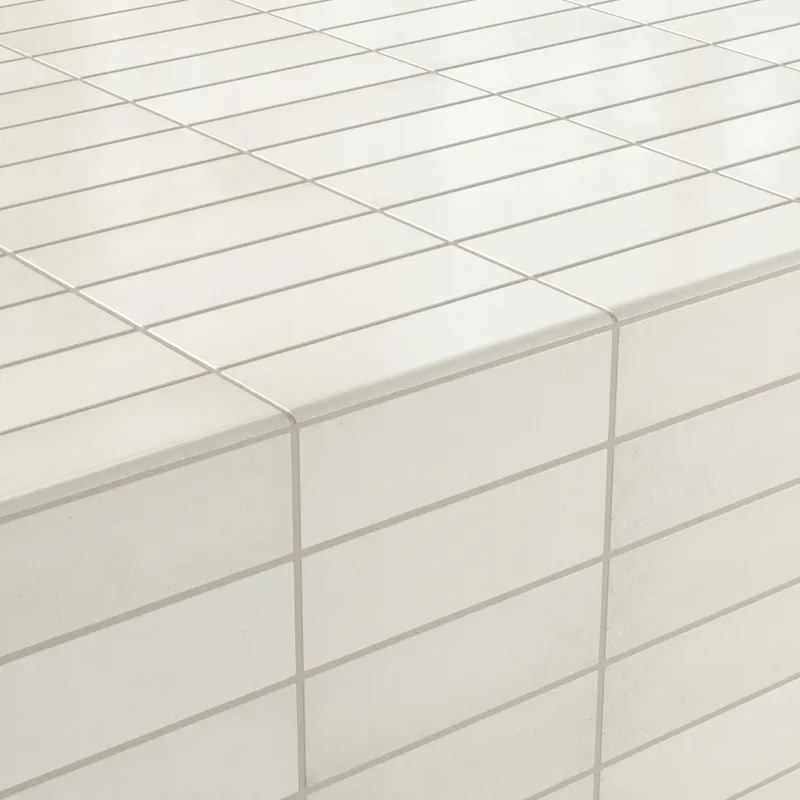 Soft white bullnose tiles framing crisp edges, offering a clean and modern finish for contemporary surfaces