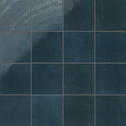Deep blue porcelain tiles with handcrafted texture and tonal shifts for a weathered look.