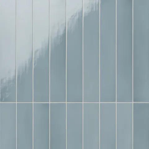 Vertical ceramic subway tiles with a subtle glossy surface, showcasing their smooth texture and soft, calming ocean blue hue