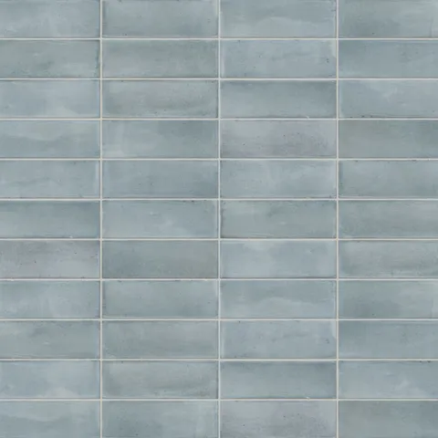 A 2x6 porcelain subway tiles in light blue, featuring a matte finish, and a clean stacked layout with fine grout lines.