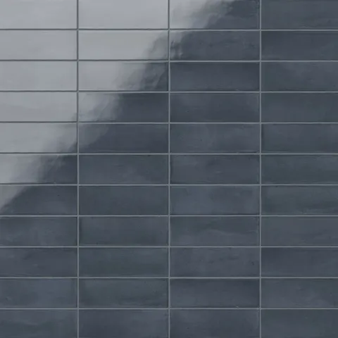 A 2x6 porcelain subway tile in blue, featuring a glossy finish, and a clean stacked layout with fine grout lines.