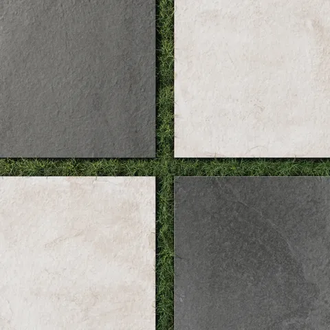 Porcelain pavers in rich charcoal and soft oat hues with lightly textured finishes, laid over grass in a checkerboard design for modern outdoor contrast.