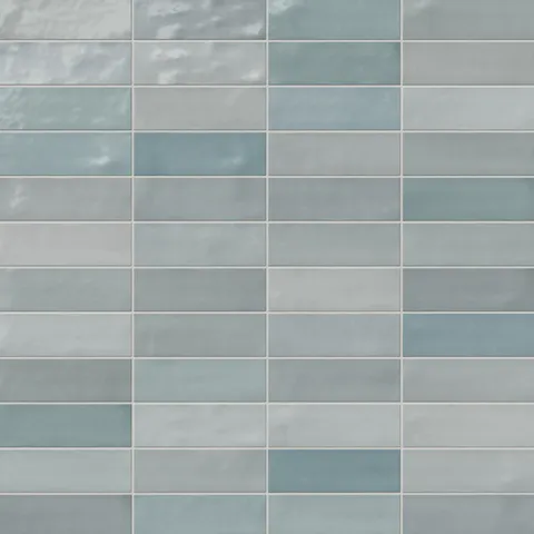 Glossy 2x8 ceramic subway tile in cool blue and gray tones, showcasing a handcrafted look with gentle color variation for a fresh coastal feel.