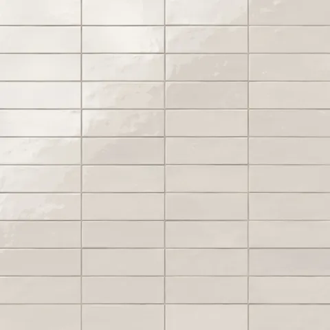 Glossy subway tiles in shifting white tones with an artisan-like surface and subtle reflective finish.