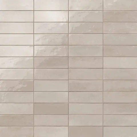 Glossy subway tiles in shifting grayish-beige tones with an artisan-like surface and subtle reflective finish