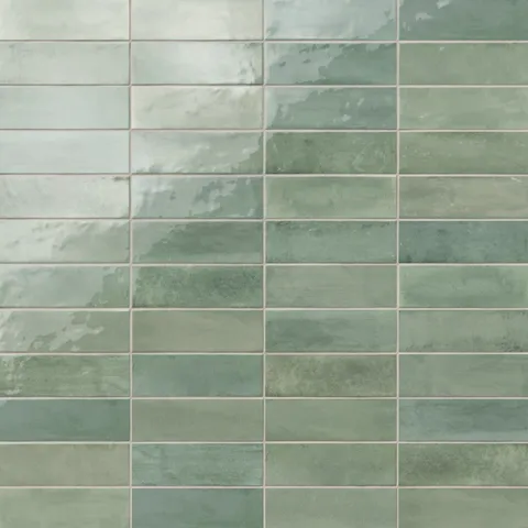 Glossy subway tiles in shifting green tones with an artisan-like surface