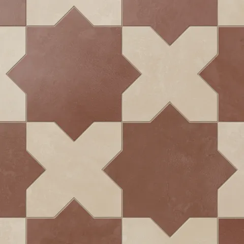 Star and cross shapes move naturally across this porcelain tile, blending red and warm beige tones with a powdery matte finish and subtle cement-plaster texture inspired by handmade terracotta.