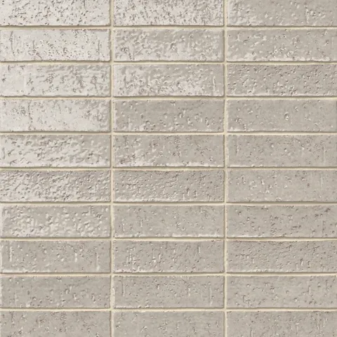 Handmade brick tiles with a gleaming grayish-beige glaze, subtle dimples, pinholes, and organic surface variation.