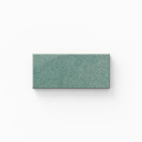 A calming seafoam tile features subtle tonal shifts and a glossy finish, bringing a fresh, airy feel that works beautifully in coastal, spa-like bathrooms.