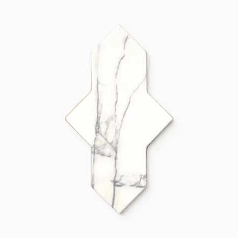 Shield-shaped Aslan 2x8 porcelain tile in white, detailed with delicate gray marble veining, a matte surface, and softened edges that give it an old-world feel.