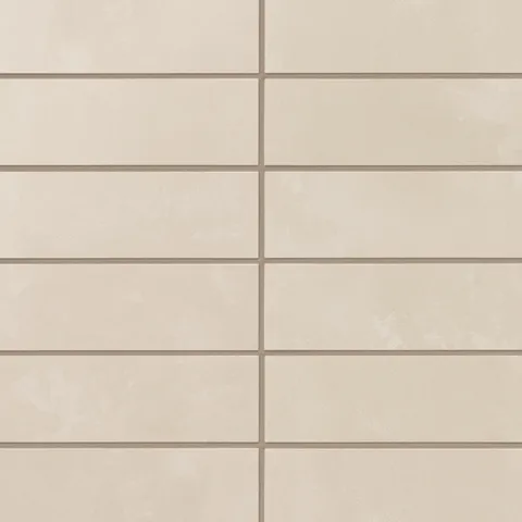 A run of 2x6 matte porcelain subway tiles reveals soft gray-beige shading, where earth-drawn variation and a powdery glaze add quiet depth to the surface.
