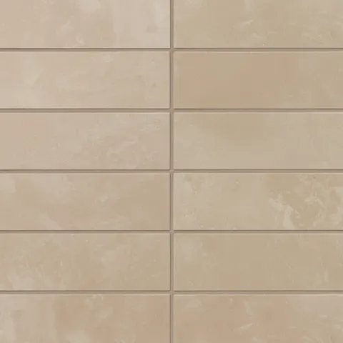 2x6 matte porcelain subway tiles in light brown show shifting, earth-drawn tones, finished with a powdery glaze that gives the wall a soft, sun-warmed look.
