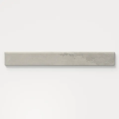 Matte bullnose tile in earthy gray tones with a soft stone-like finish, perfect for smooth edge transitions on walls, countertops, or backsplash installations.