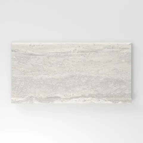 Light gray travertine-look porcelain 6x12 cove base tile with delicate linear veining, subtle texture, and a clean stone appearance.