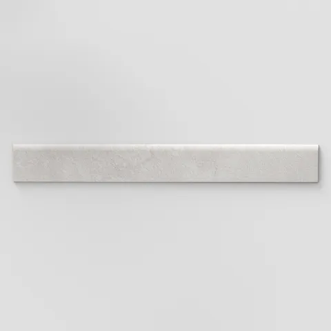 Elongated subway-style trim with a curved front edge, featuring a subtly textured surface and soft light gray tones.