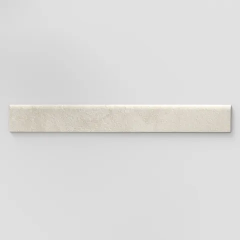 Elongated subway-style trim with a curved front edge, featuring a subtly textured surface and soft grayish beige tones inspired by hand-formed clay.