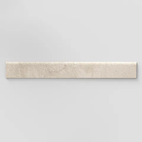 Elongated subway-style trim with a curved front edge, featuring a subtly textured surface and warm beige tones inspired by hand-formed clay.
